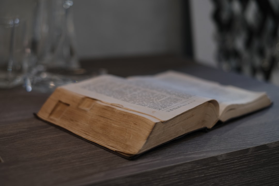 An open book resting on a worn wooden table, a page from the reading list mid-lesson