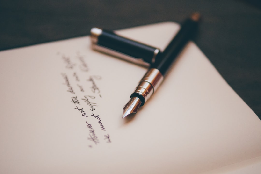 A fountain pen resting on handwritten stationery, marking essays the old way before it becomes a grade