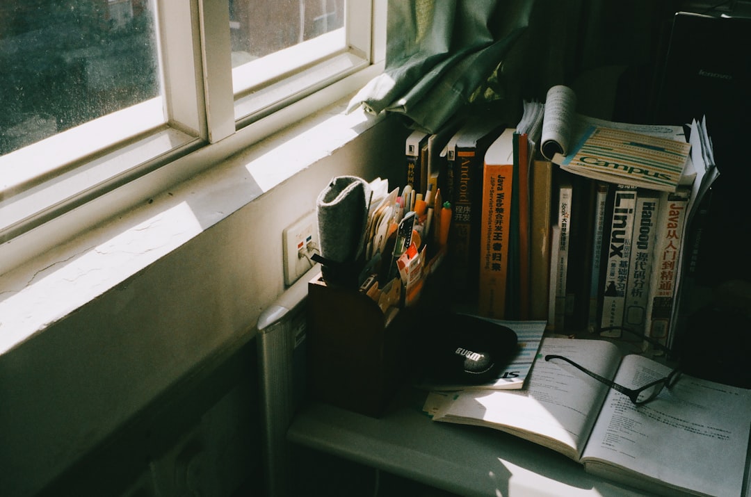 Books and reading glasses laid out on a table by a window, the reading table before a community day
