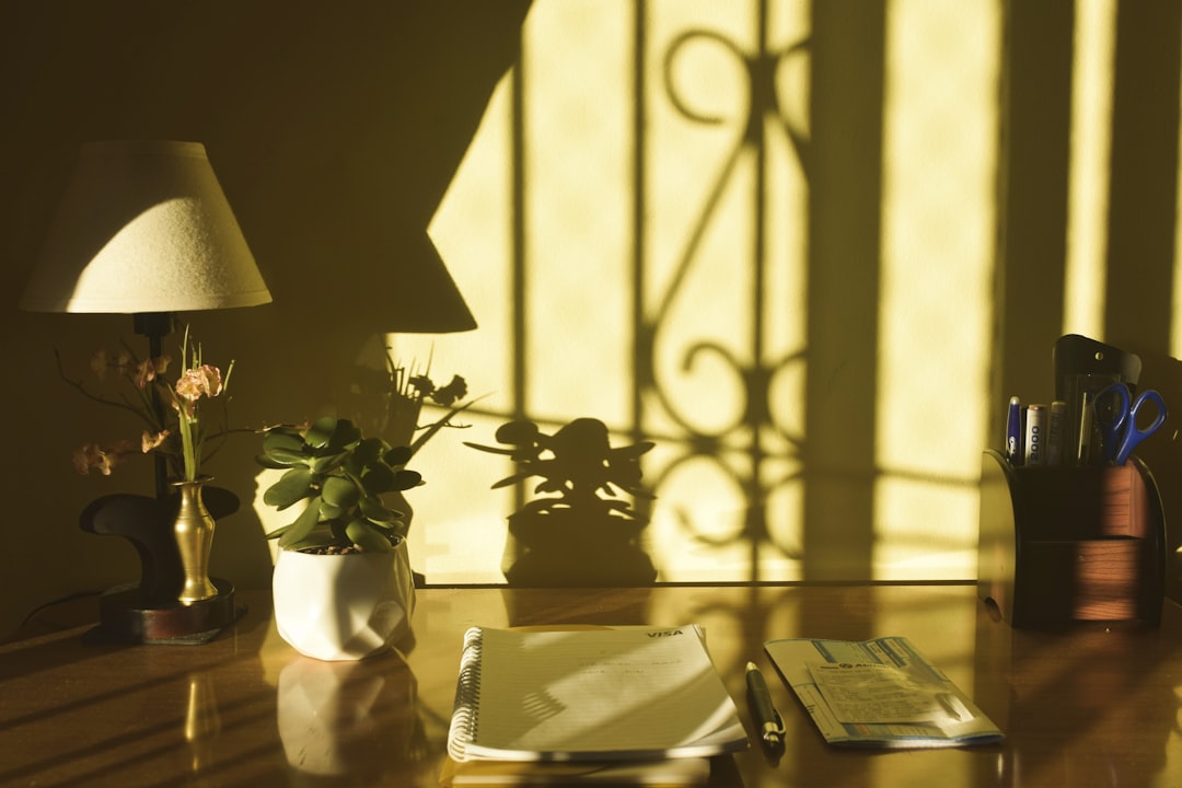An open workbook and a lamp on a home desk, set up for a home day