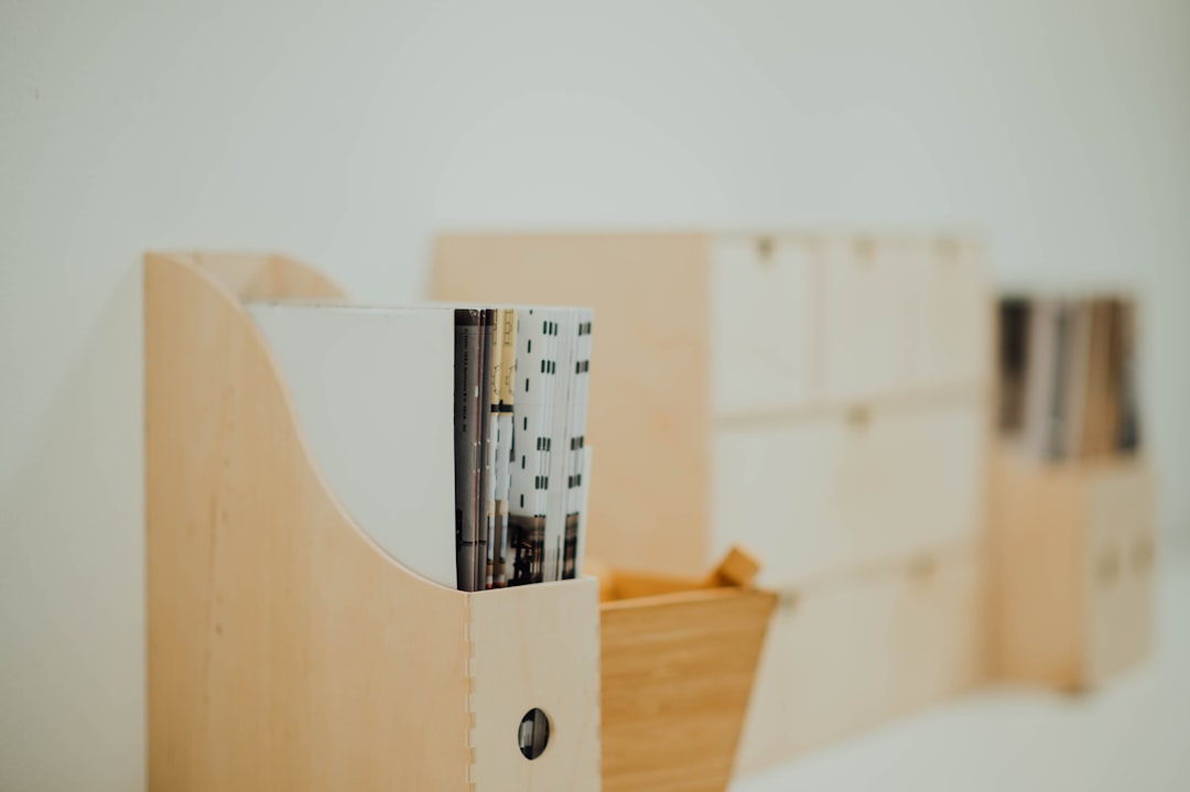 Books arranged upright in a low wooden shelf organizer, set at a child's height